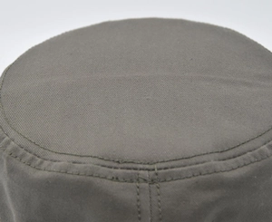 Vue macro détaillée d'une casquette camouflage en coton montrant les doubles coutures du tissu