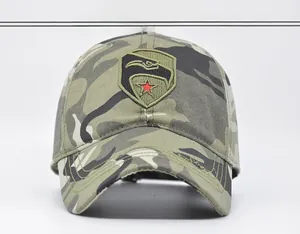 Detail of army camouflage baseball cap featuring a black hawk and red star shield embroidery