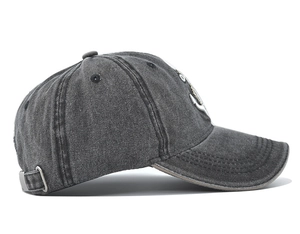 Detail view of washed cotton baseball cap featuring vintage anchor patch and metal buckle
