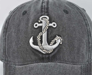 Close-up of anchor embroidery on vintage washed denim baseball cap with detailed stitching