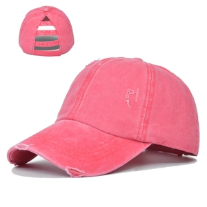 Detail of pink washed cotton ponytail baseball cap with distressed holes and elastic bands