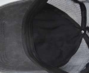 Detail view of the washed cotton fabric, breathable mesh, and sweatband inside the cap