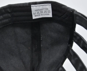 Detail of internal wash label showing 100% cotton fabric and care icons on black cap