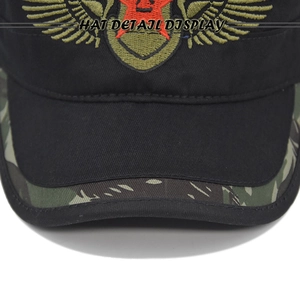 Close-up of military flat top cap featuring embroidered red star and camo brim detailing