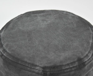 Detailed macro view of the distressed washed cotton fabric and stitching on a flat top army cap