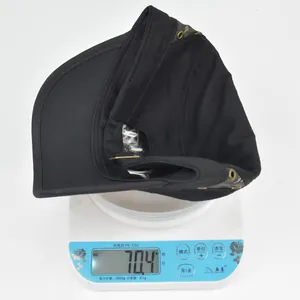 Detail showing flat top baseball cap on scale weighing 70.4 grams with camo accents