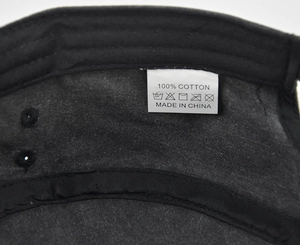 Detailed macro view of the 100% cotton washing label inside the black military flat top cap