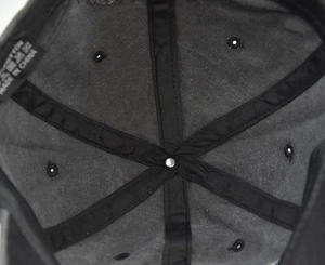 Macro detail of NEW YORK baseball cap interior showing 100% cotton label and reinforced stitching