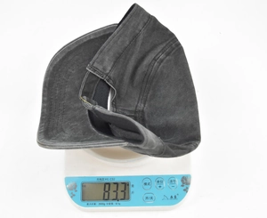 Detail view of a vintage washed grey military cap weighing 83.3g on a digital scale