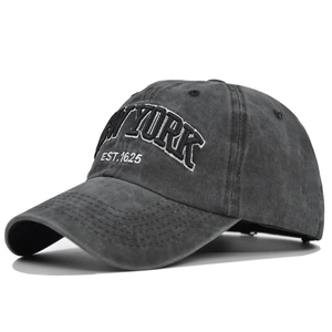 Close-up of NEW YORK embroidery on dark gray washed cotton baseball cap with stitch detail