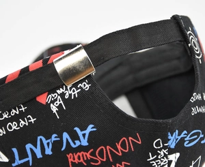 Détail de la boucle métallique et de l'imprimé graffiti sur la casquette en coton noir