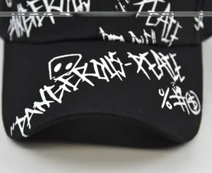 Close-up of the cotton baseball cap showing graffiti print and fabric texture detail