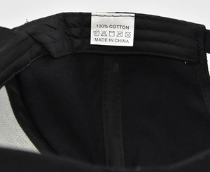 Detailed macro view of the 100% cotton material label and inner stitching on a black cap