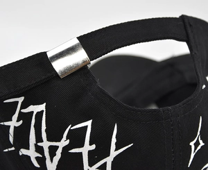 Close-up of black cotton baseball cap showing silver metal buckle and graffiti print
