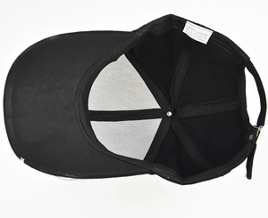 Internal detail of black cotton baseball cap showing white mesh lining and wash label