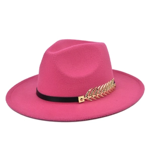 Detail van roze wollen vilten fedora met zwarte lederen band en gouden bladdecoratie