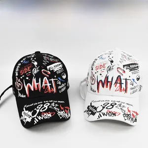 Detailed comparison of black and white graffiti print baseball caps with street style art