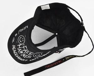 Detail of internal cotton label and adjustable colorful graffiti strap on black baseball cap