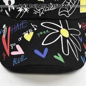 Graffiti printed black baseball cap featuring colorful street art and daisy patterns