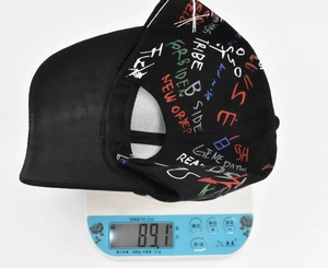 Close-up showing the lightweight design of this black graffiti baseball cap on a scale