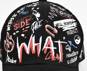 Close-up of black canvas baseball cap with graffiti prints and WHAT embroidery detail
