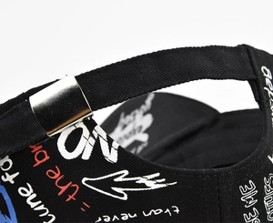 Detail of adjustable metal buckle and strap on graffiti printed black baseball cap