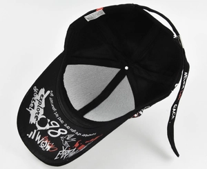 Detail of black cotton baseball cap showing graffiti brim and long adjustable strap