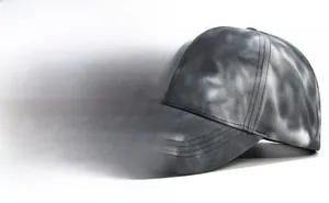 Detailed shot of tie-dye baseball cap featuring black and gray vintage cotton canvas texture