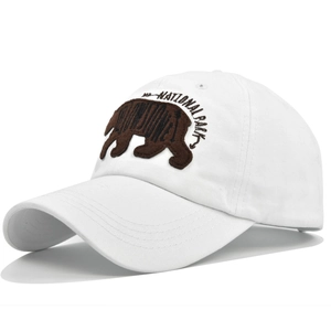 Close-up of brown bear patch and National Park embroidery on a white baseball cap