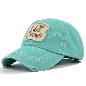 Close-up of mint green washed baseball cap with I do Crew! 3D embroidery and distressed details
