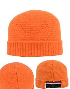 Détail du bonnet en maille gaufrée orange avec boucle de réglage noire à l'arrière du chapeau