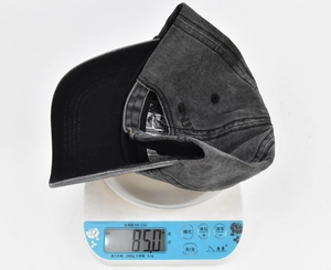 Detailed weight display of the black bear patch baseball cap on a digital scale at 85.0g