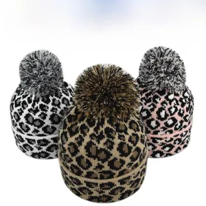 Various color options for leopard print knit beanies with large mixed-color fluffy pom-poms