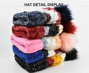 Cinq bonnets en grosse maille empilés avec des pompons en fausse fourrure colorés