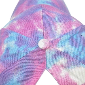 Detail of pink and blue tie-dye baseball cap showing cotton twill fabric and top button