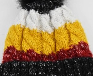 Détail du bonnet en maille torsadée multicolore avec pompon et texture épaisse