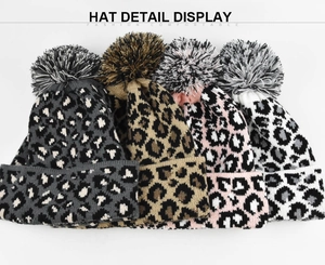 Detail display of stylish leopard print knit beanies with large fluffy pom poms in four colors