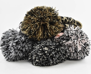Close-up of thick winter knit hats featuring leopard print patterns and large fluffy pom-poms