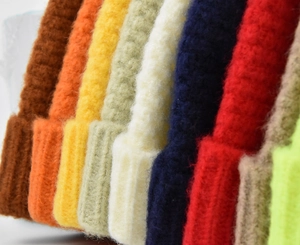Gros plan détaillé de bonnets en maille côtelée colorés montrant la texture douce