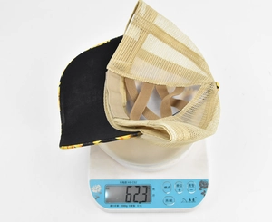 Detail view of sunflower ponytail cap on a scale showing lightweight 62.3g mesh design
