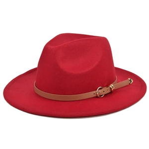 Detail of red wool fedora hat with brown leather band and gold buckle on white background