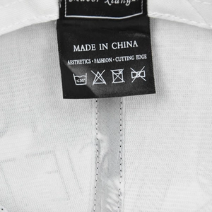Vue macro de l'étiquette de lavage noire avec texte Made in China sur casquette blanche