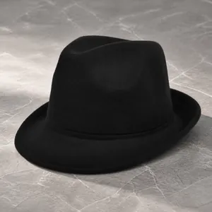 Detail view of the black felt fedora hat featuring a classic curved brim and crown indent