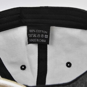 Detail view of the 100% cotton wash label and inner lining on a washed denim baseball cap