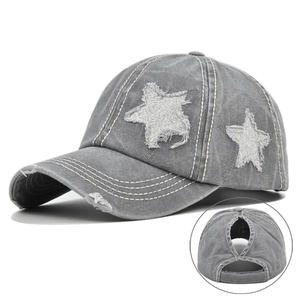Detail view of washed grey baseball cap featuring silver glitter stars and ponytail hole