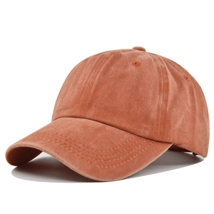 Detail showing vintage washed cotton fabric texture and stitching of burnt orange cap