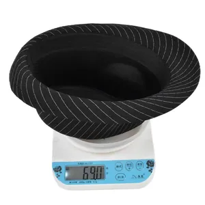 Classic black pinstripe fedora hat being weighed at 69.0g on a scale for shipping weight