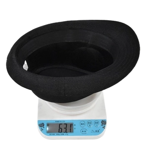 Detail view of lightweight black fedora hat weighing 63.1g on a digital scale