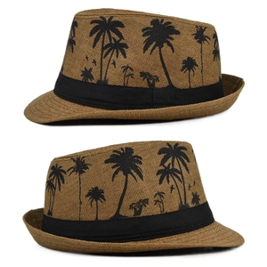 Detailed view of brown straw fedora hat featuring black palm tree prints and a black band