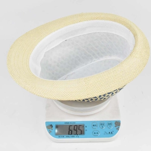 Detail view of lightweight paper straw jazz hat weighing only 69.5g on a digital scale